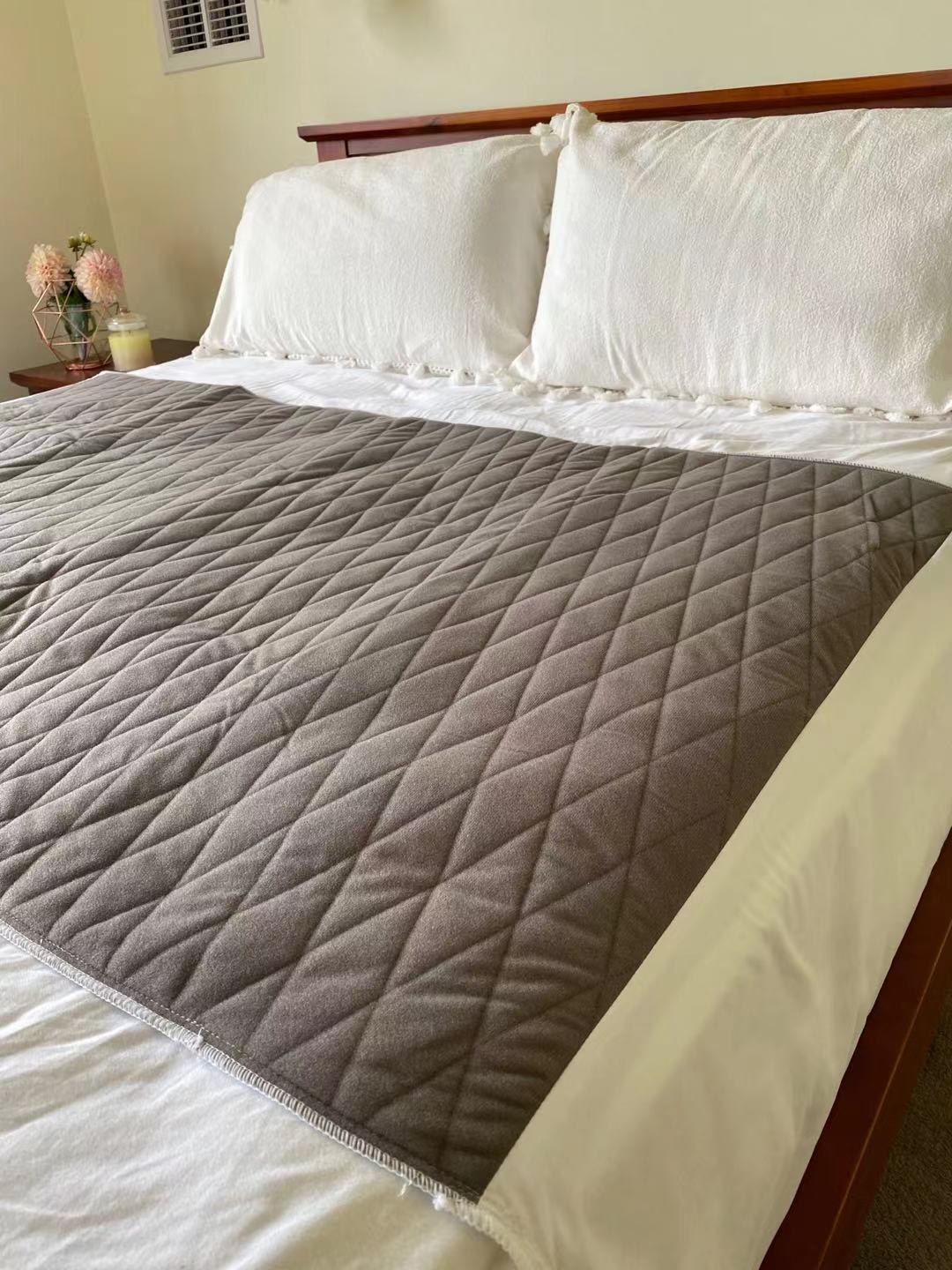 Blue-e bed pad laid out on a queen size bed